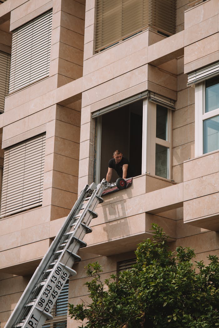 why-choose-us A man standing on a telescopic ladder at a residential building in Valencia, Spain.